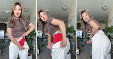 A woman demonstrating that red underwear doesn't show under white clothes