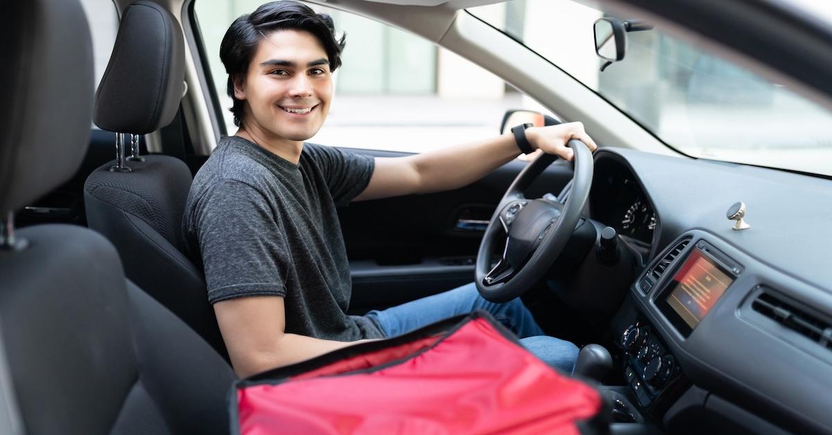 A food delivery man seated in a car