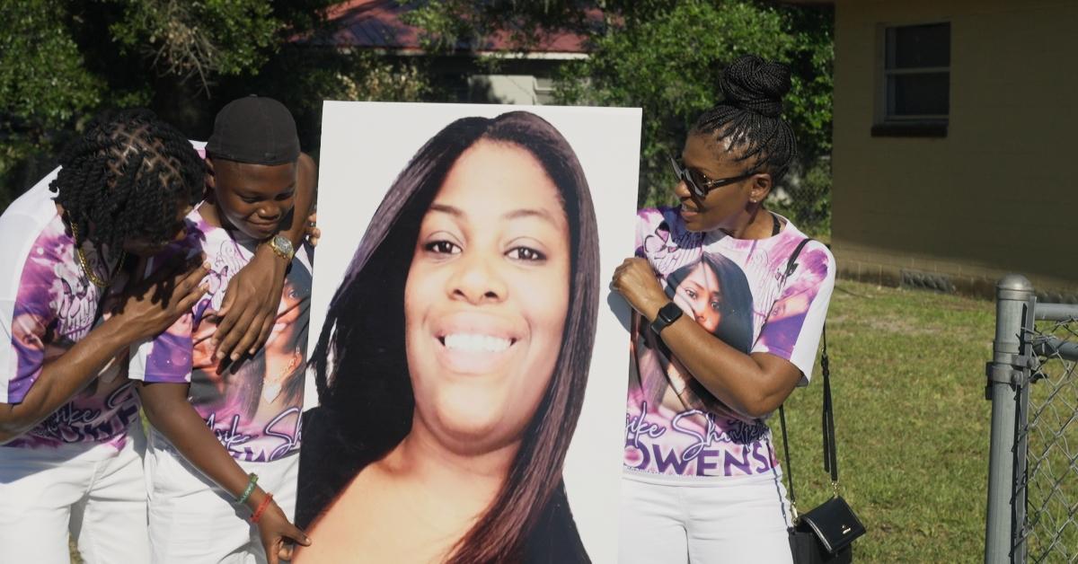 Ajike Owens' family holds up a photograph of her