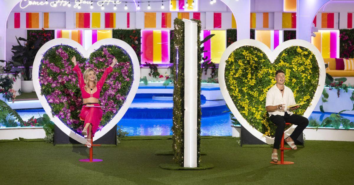 Kaylor Martin and Aaron Evans play a dating game style challenge seated on opposite sides of a wall on 'Love Island USA'