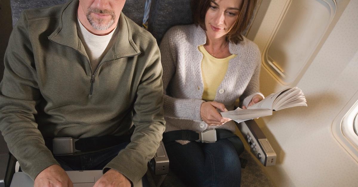 A man and a new woman sitting next to each other on an airplane