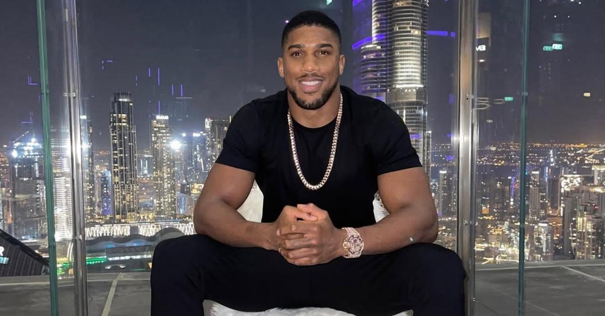 Anthony Joshua sits in a rooftop bar.