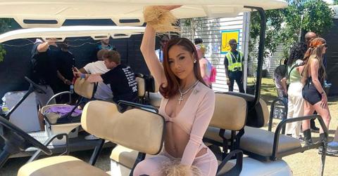 urry sleeves Mariah the Scientist wears pink outfit with furry sleeves, poses on the back of a golf cart.