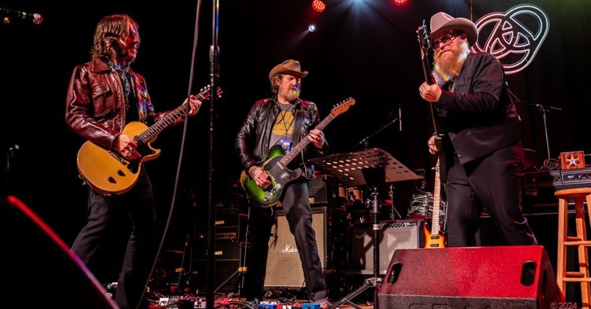 Brent Hinds performing with other musicians in concert.