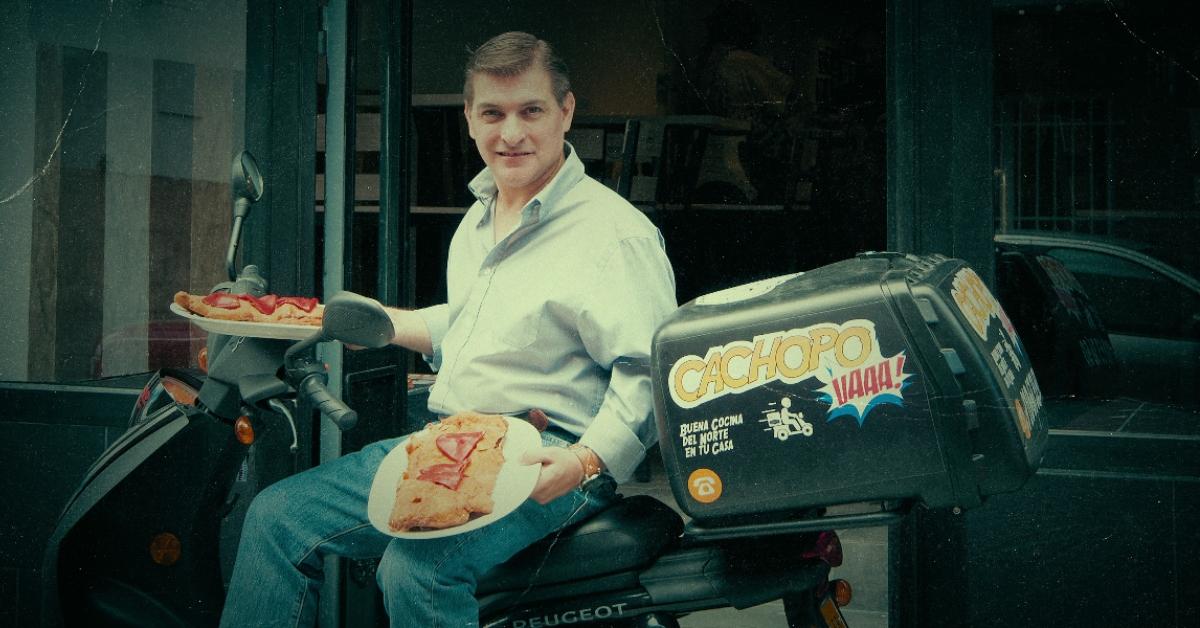 César Román holding two plates of his signature dish