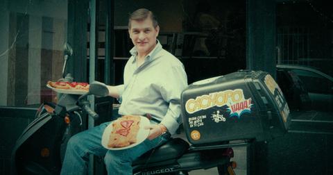 César Román holding two plates of his signature dish