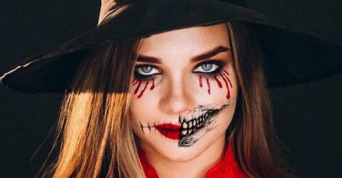 Woman in witch hat with Halloween temporary tattoos on face