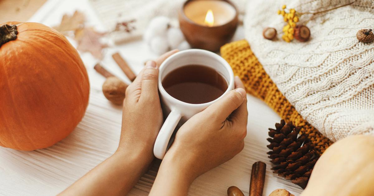 A fall aesthetic featuring a mug of tea and pumpkins.