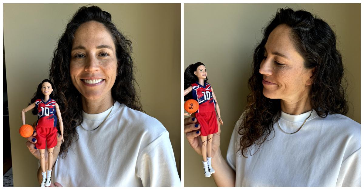 Sue Bird smiles and poses with the "Barbie Sue Bird Role Model doll."