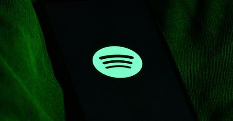 The Spotify logo on a phone.