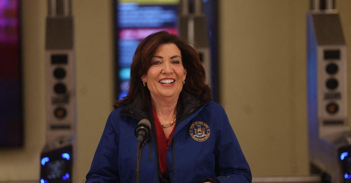 Kathy Hochul speaking in front of a subway entrance. 