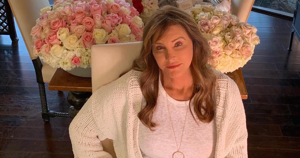 Caitlyn Jenner in front of two bouquets of roses