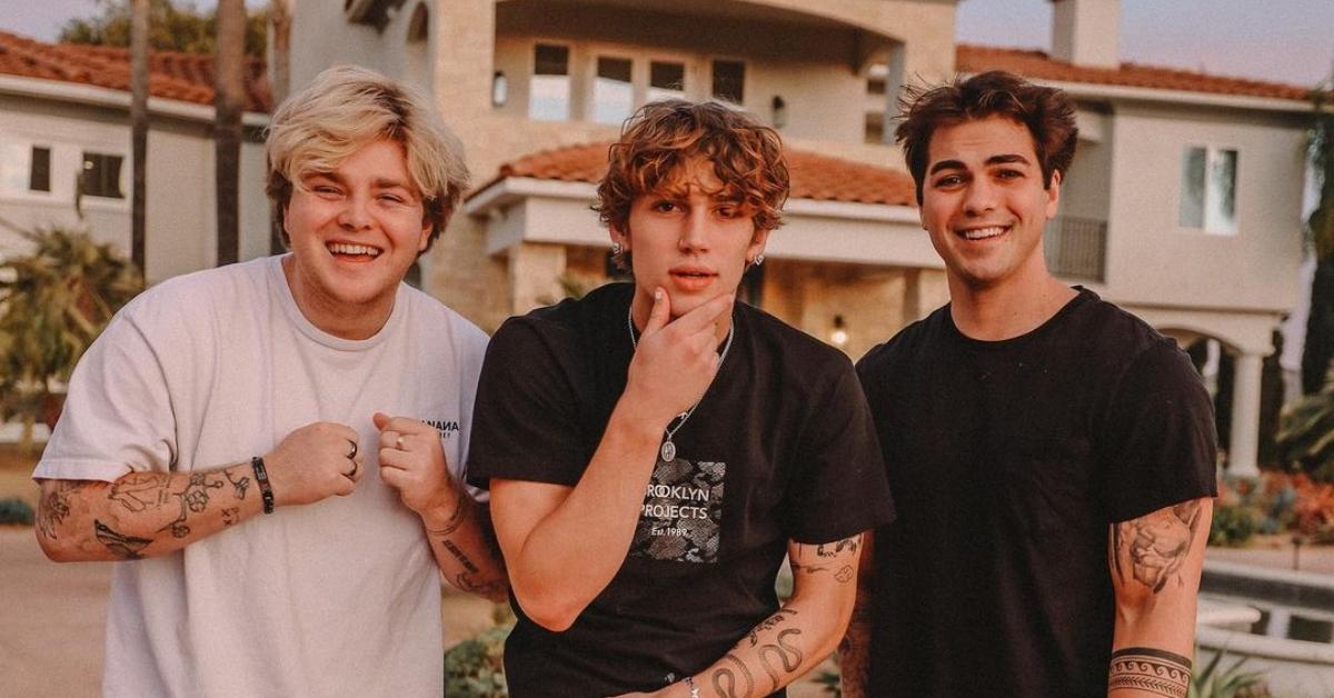 Alex Warren, Vinnie Hacker, and Thomas Petrou smile in front of the Hype House in California.