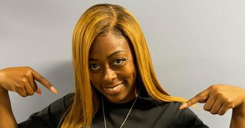 Tiffany Henyard pointing at her own t-shirt.