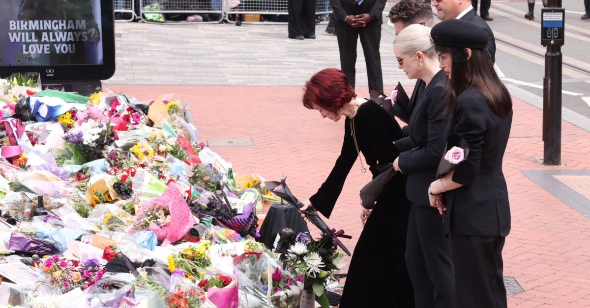 Sharon Osbourne leaves flowers on a memorial for Ozzy, as their children Jack and Kelly look on