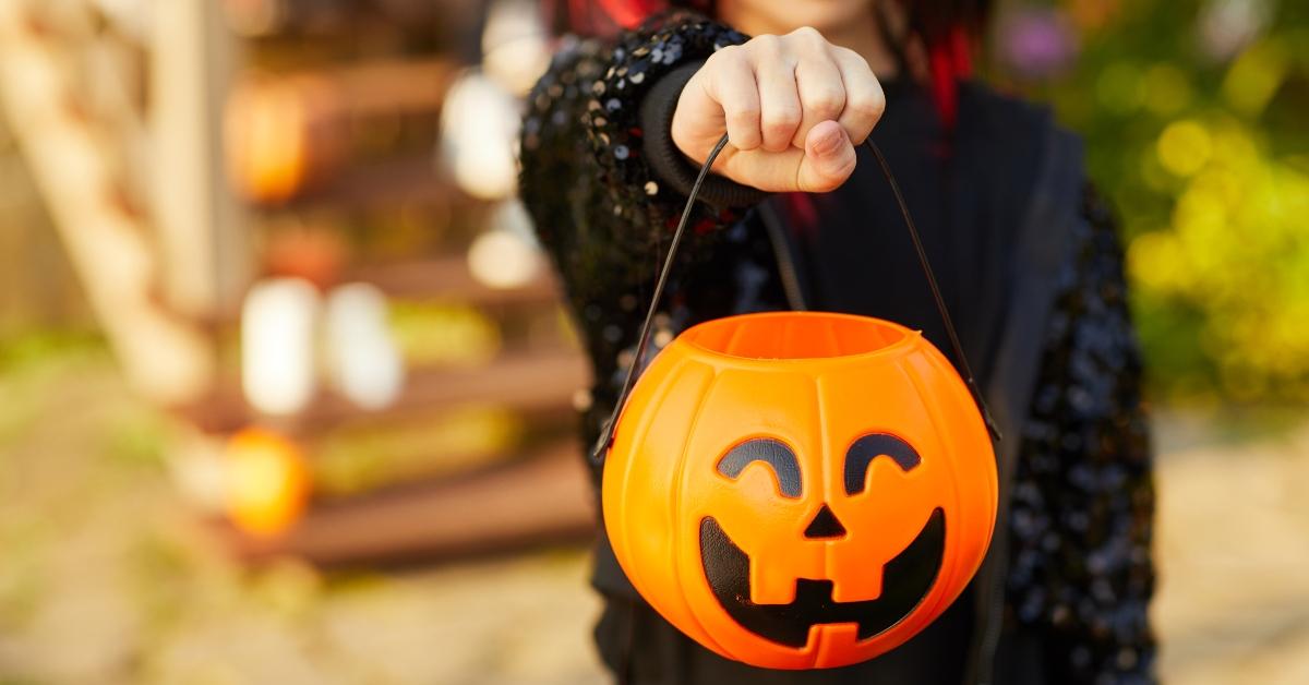 kid trick or treating with pumpkin bucket