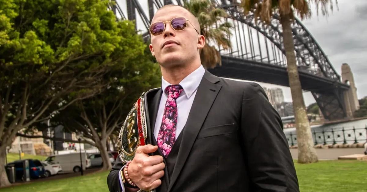 Kyle Fletcher holds his AEW belt.