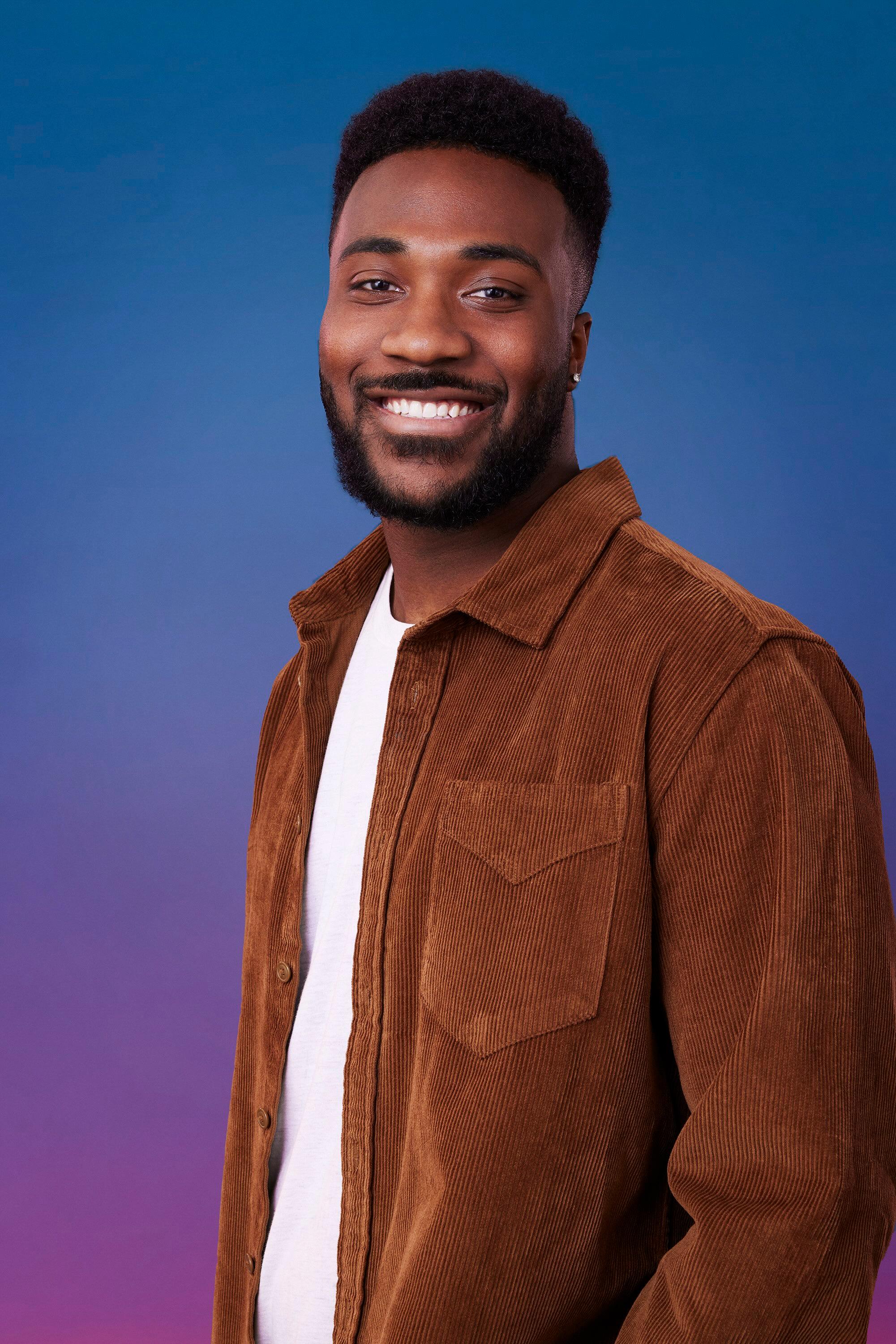 Dylan poses in front of a blue-purple ombré background for his official 'The Bachelorette' Season 21 portrait.