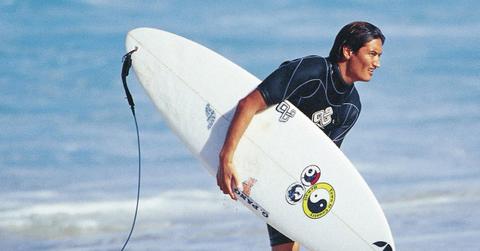 Mikala Jones with a surfboard on the beach