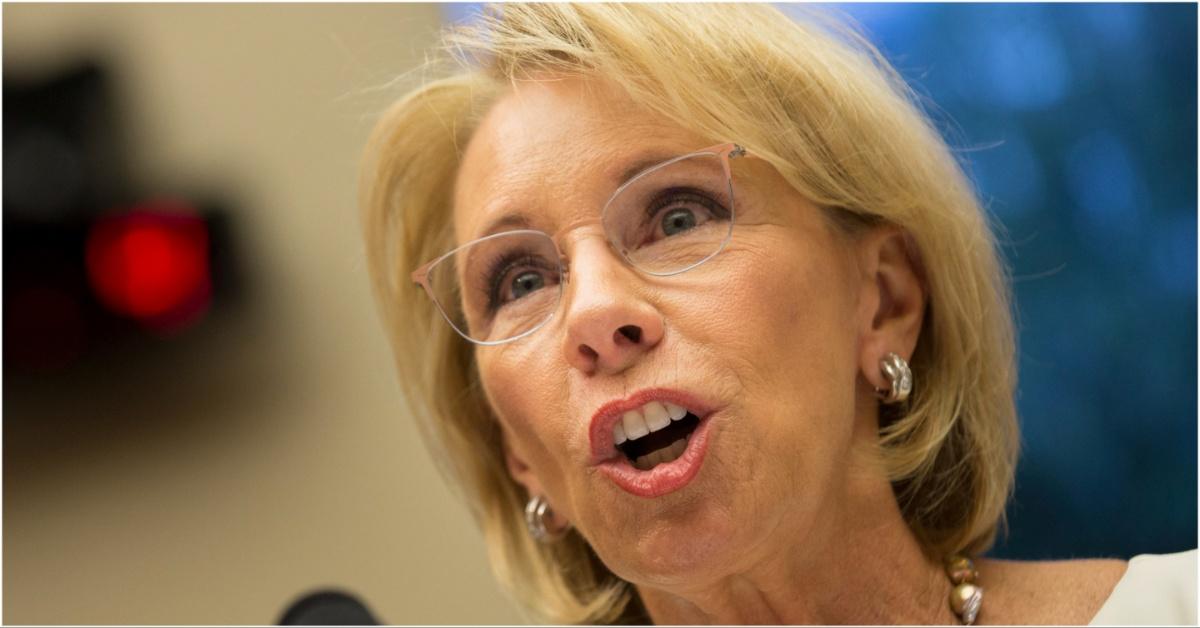 Betsy DeVos speaking into a microphone