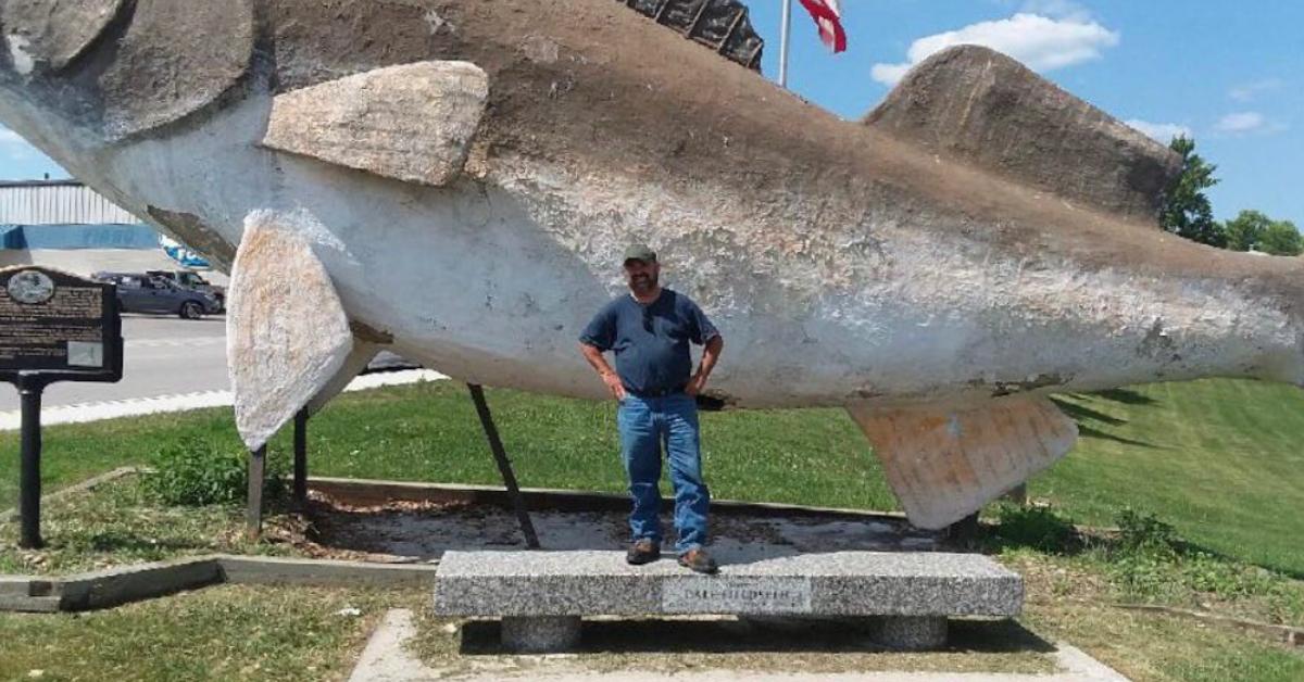 Frank Fritz posing in front of a fish statue.