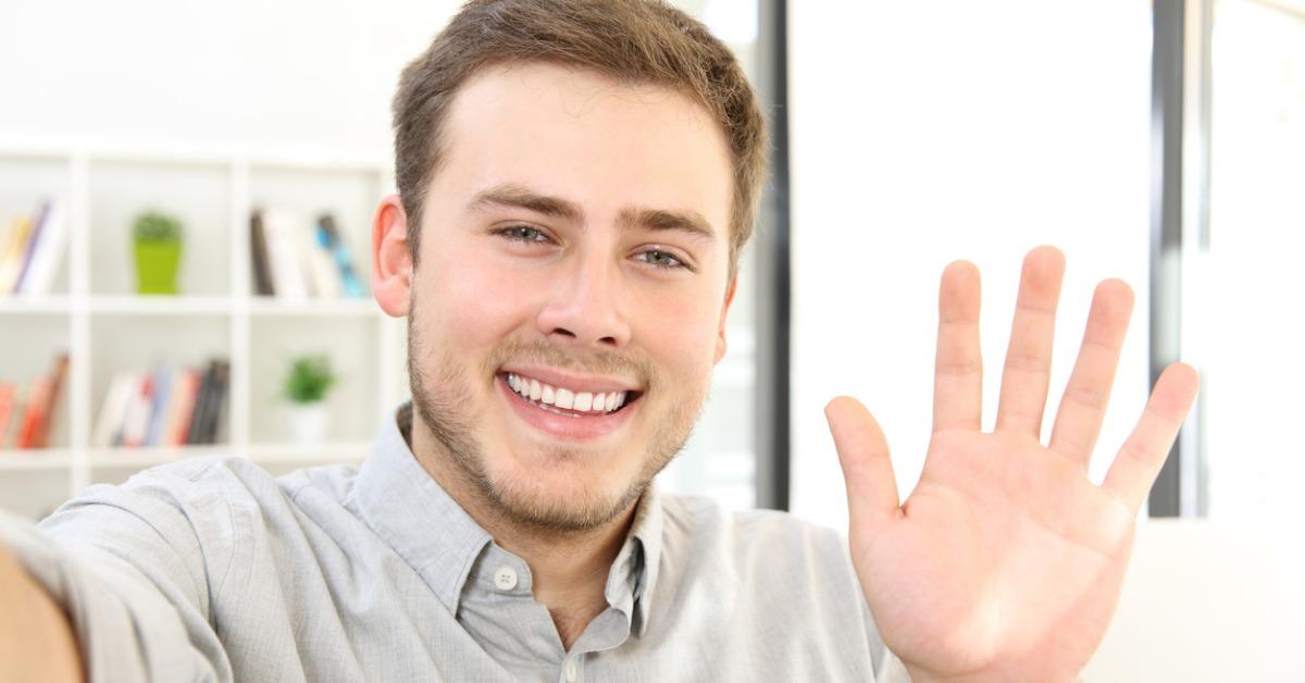 man waving on a video call at home picture id