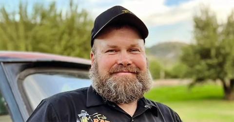 Ben in a hat with a truck behind him.