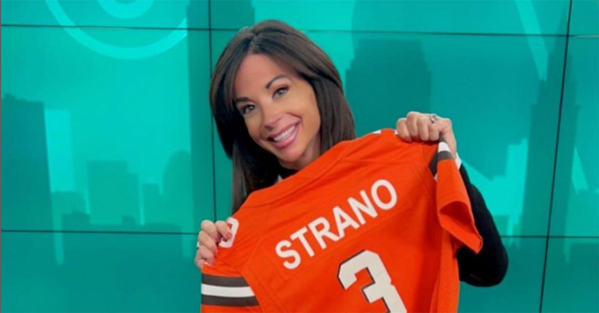 Hollie Strano holding an orange jersey with her last name on it. 