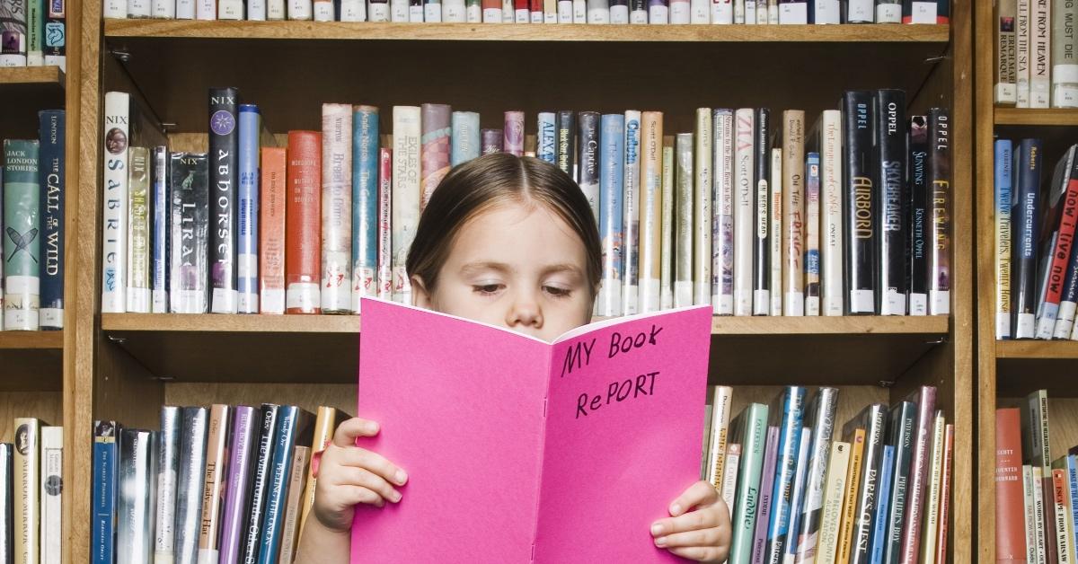 Girl reading book report.