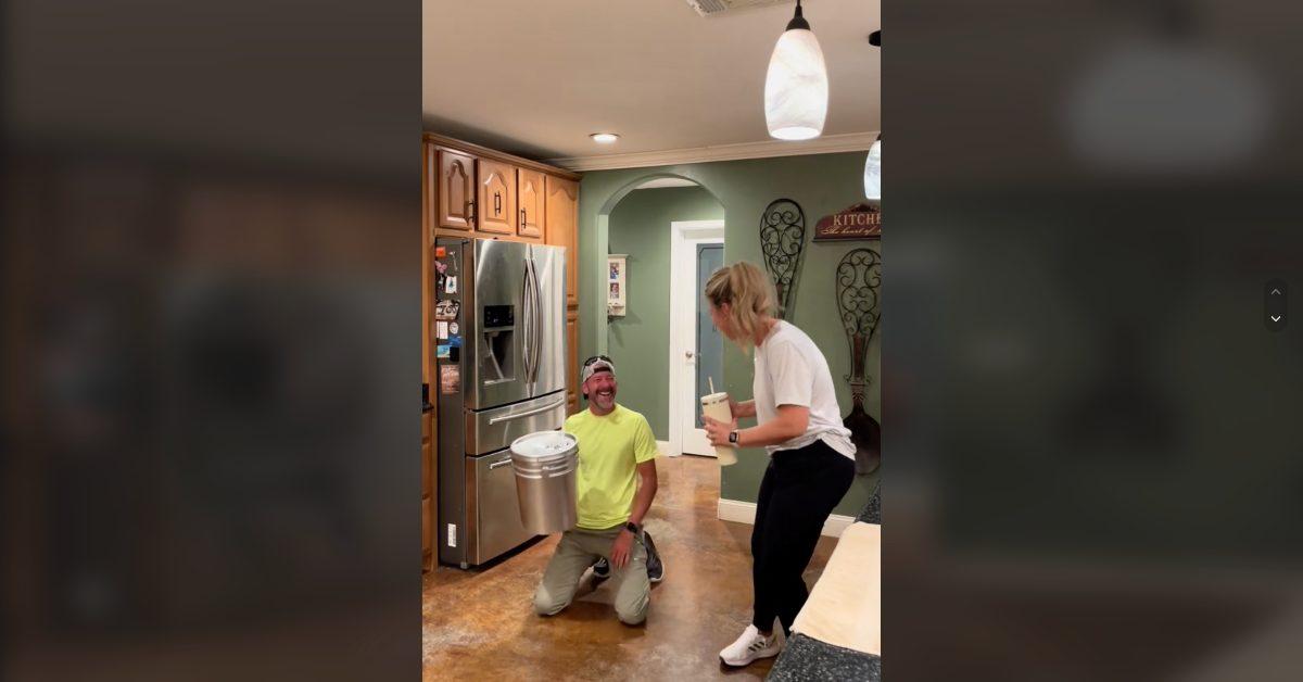 A husband and wife laugh at his giant water bottle