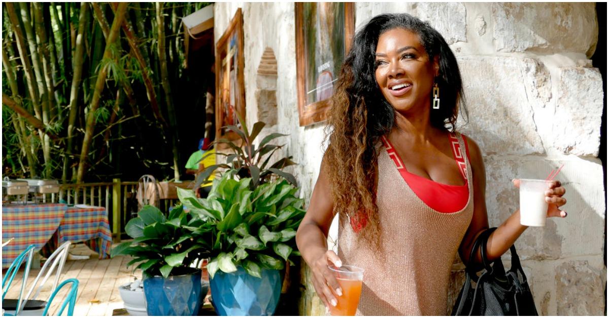 Kenya Moore holding two drinks while filming 'RHOA' Season 14