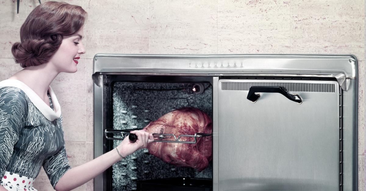 Woman checking a roast in oven