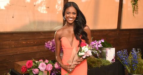 Charity Lawson dons a coral gown while holding a bouquet of flowers.