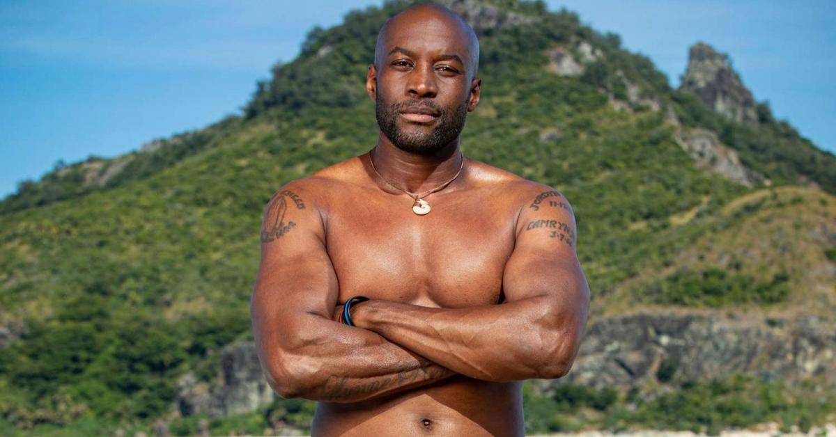 Jeremy Collins stands in front of a mountain  on Survivor