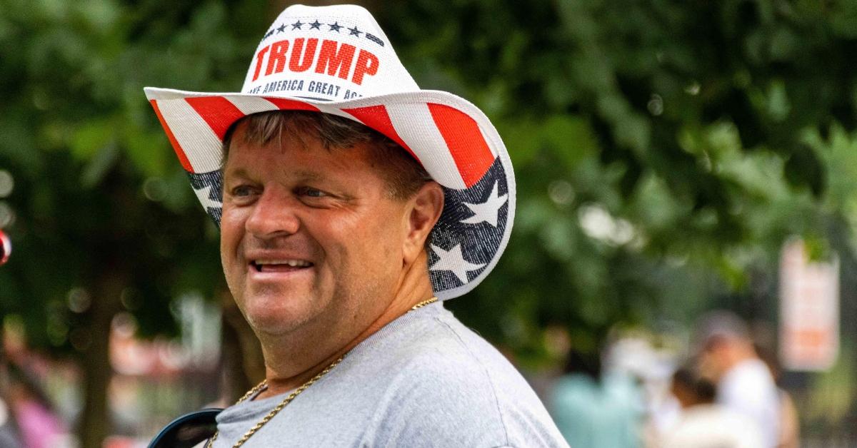 A man wears a Trump MAGA hat at a Trump Military Parade in June 2025.