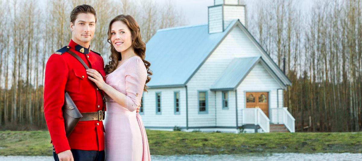 Jack and Elizabeth in 'When Calls the Heart' standing by a white house.