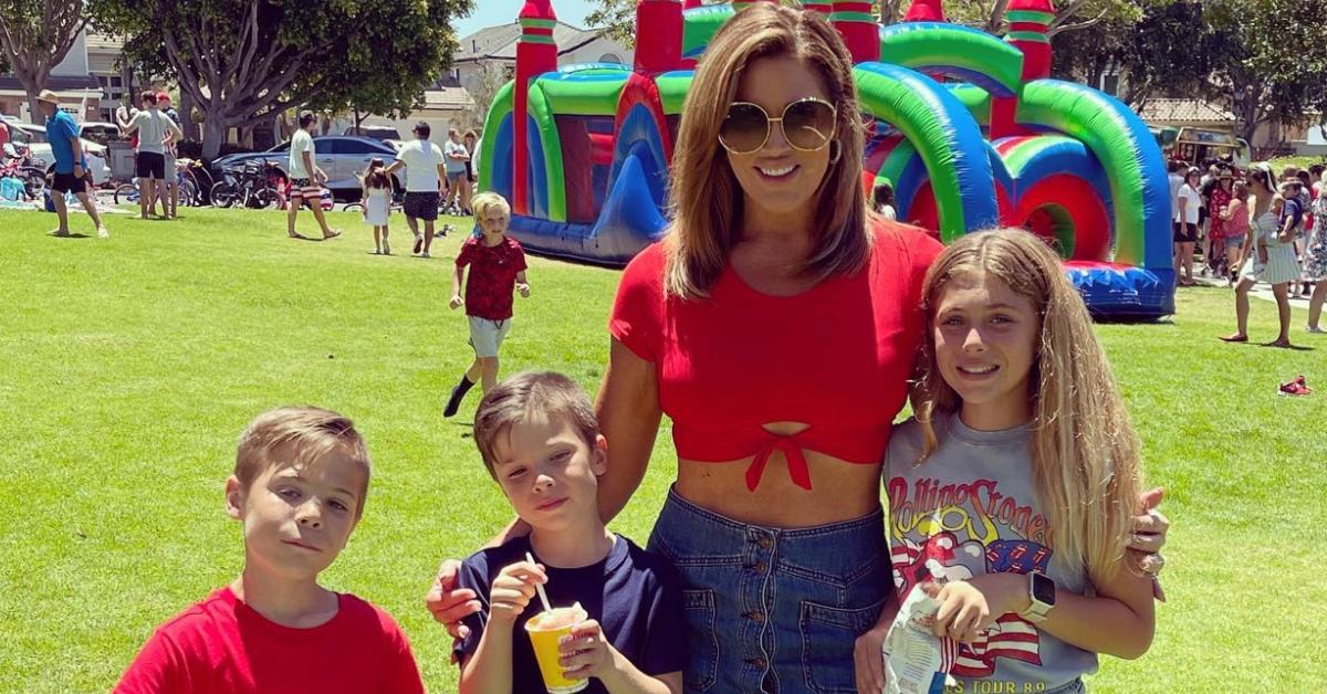 Emily Simpson and her three kids attend an outdoors event.