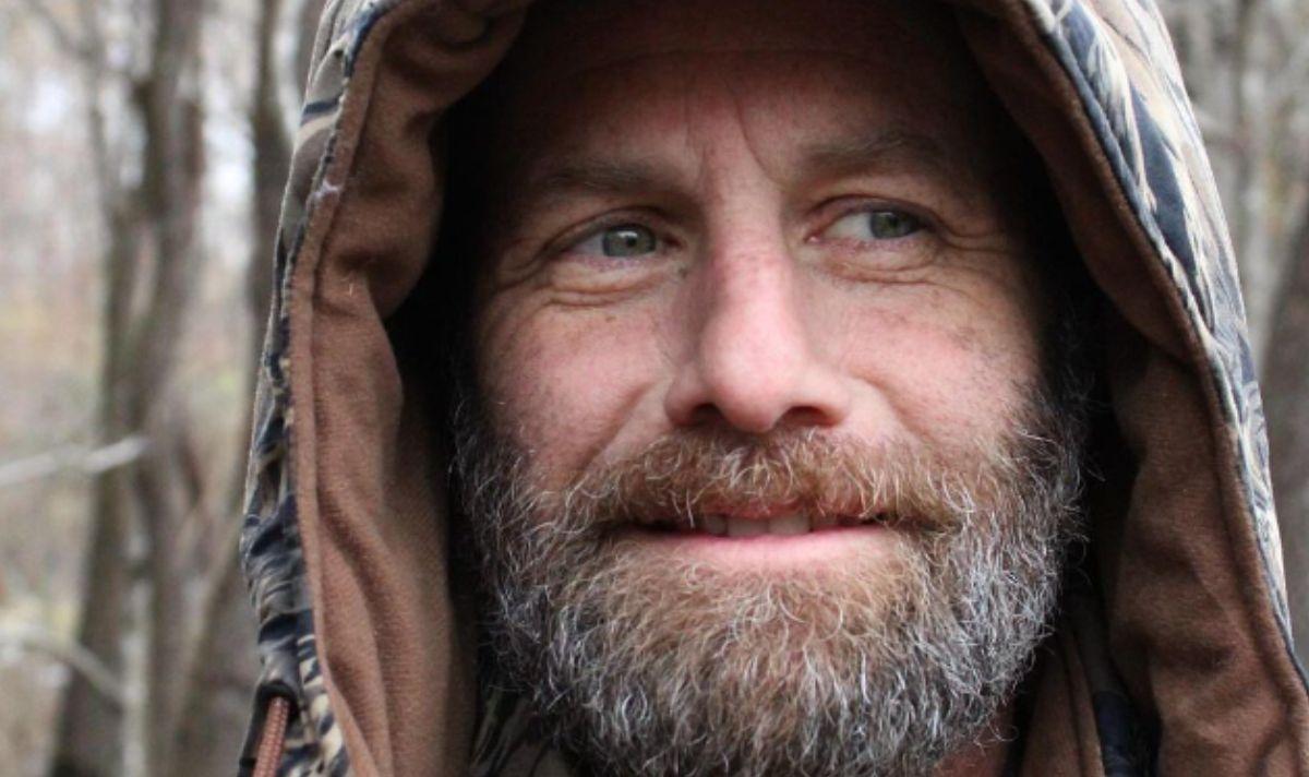 Kirk Cameron poses in a camo jacket in the woods