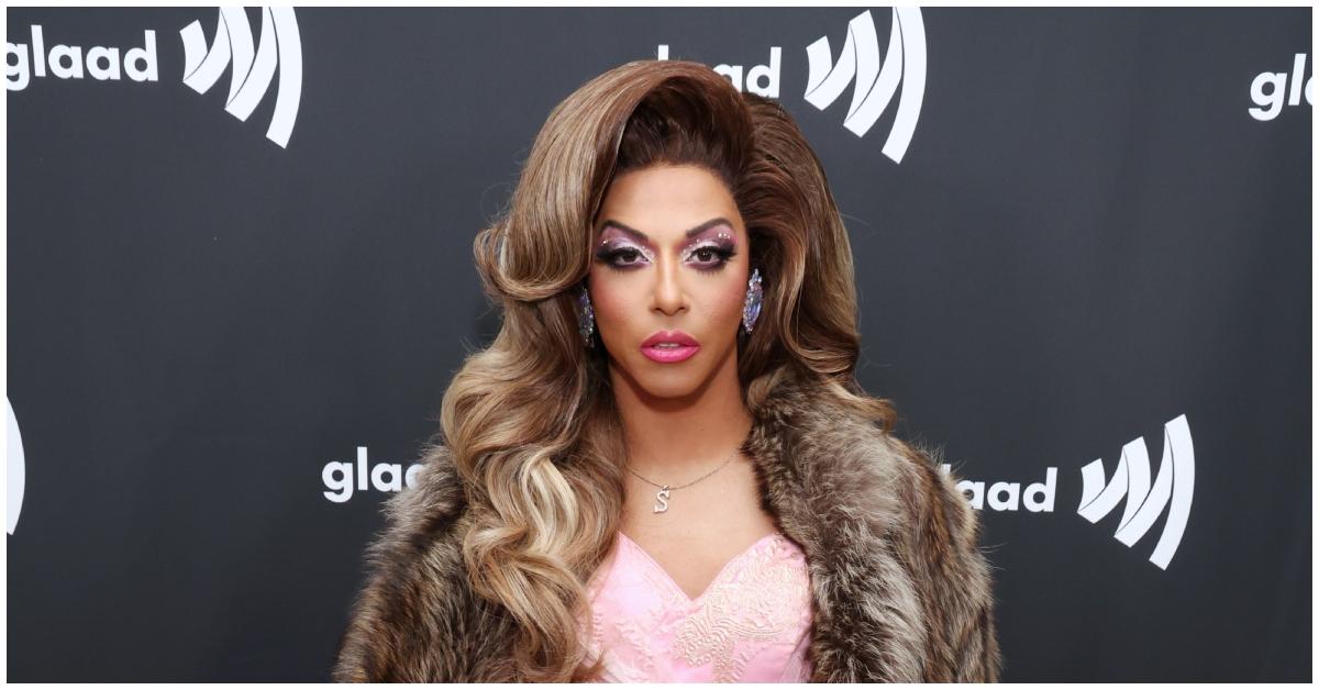 Shangela in pink dress and fur coat on red carpet