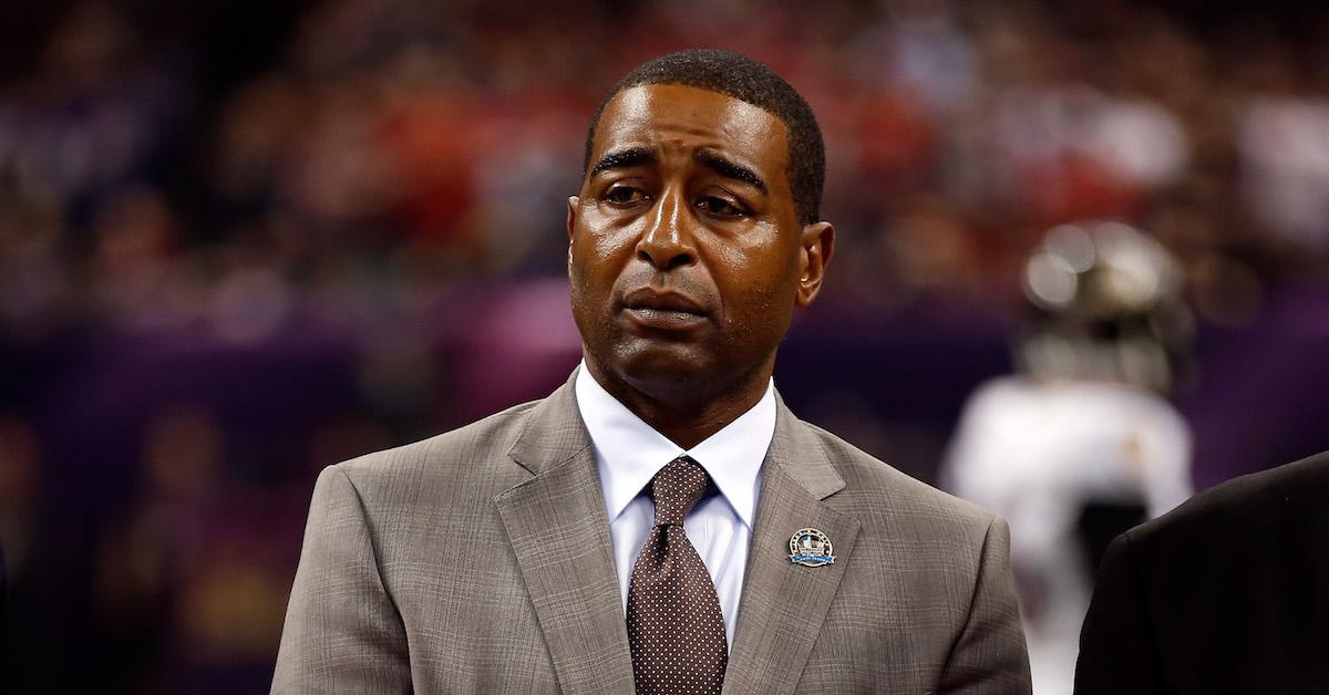 Cris Carter, right, receives his symbolic gold jacket from his