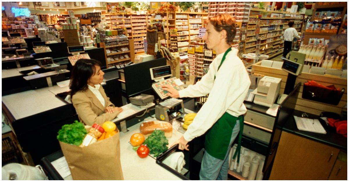 A cashier checking out a customer at a grocery store.