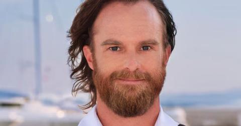 Iain Maclean poses in uniform in front of the sea