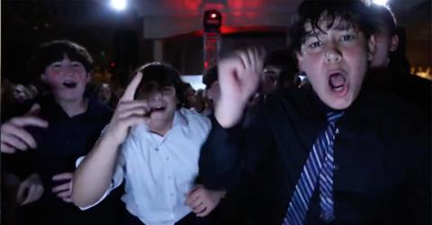 A group of boys singing along to 'Carnival' by Kanye West.