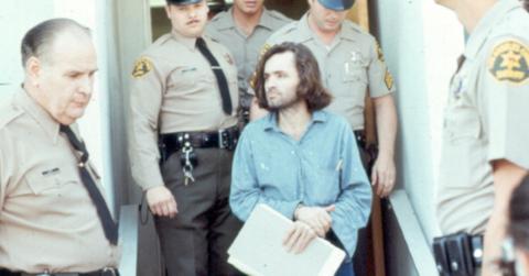 Charles Manson being led by police officers