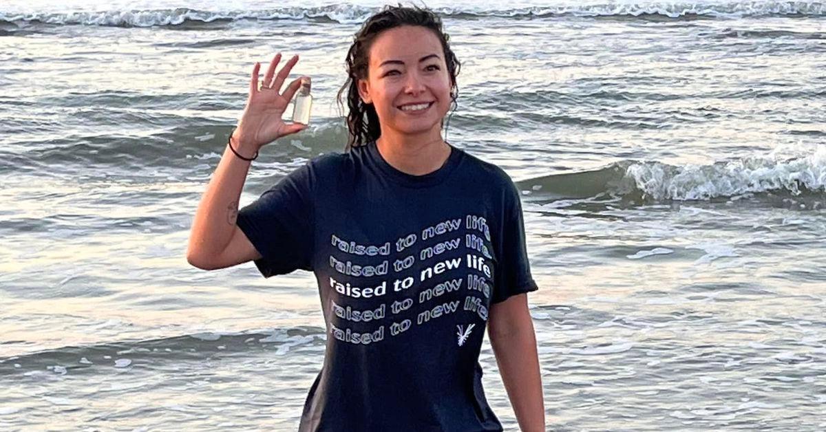 Mica Miller in a blue tee shirt with the ocean in the background