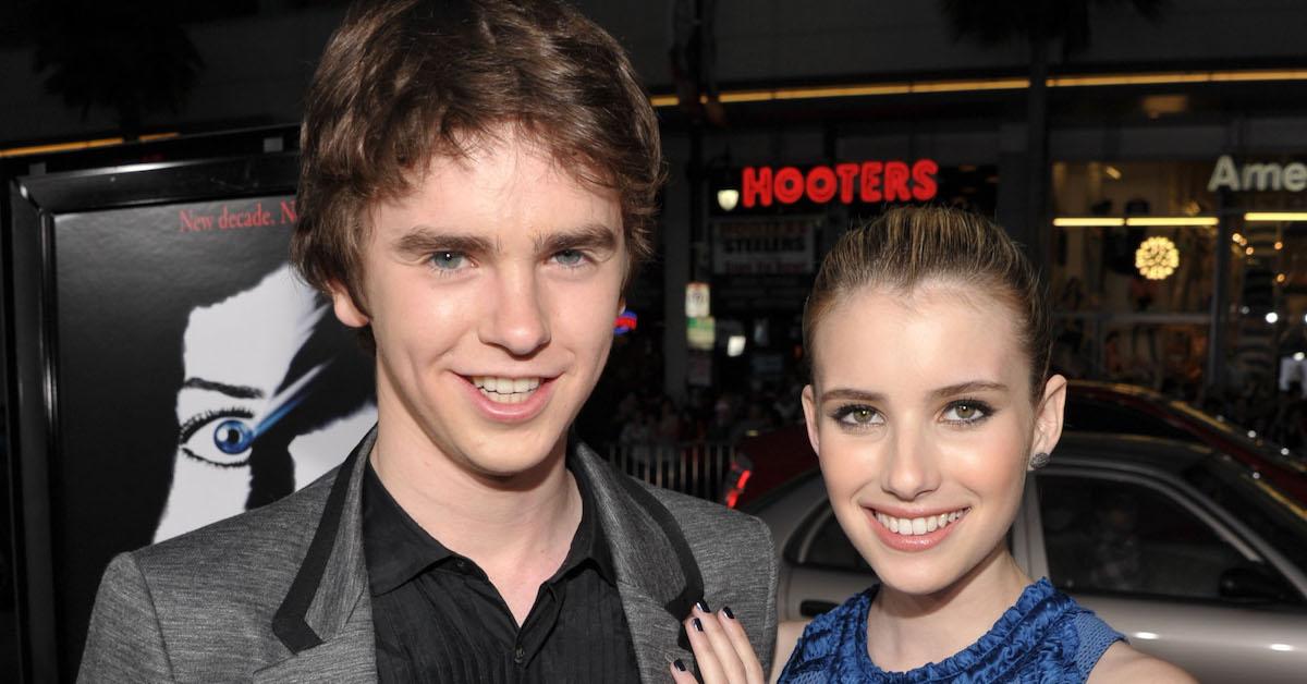 Freddie Highmore poses with Emma Roberts at an event.