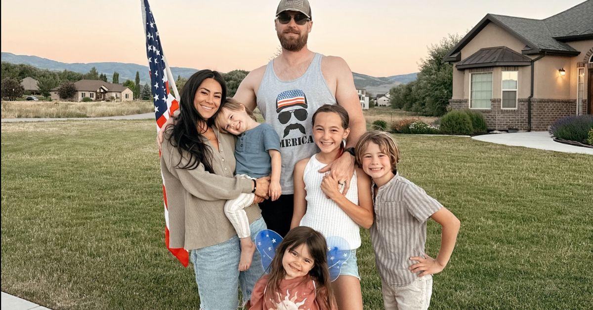 Meili Workman stands holding her youngest child next to her husband and three other kids