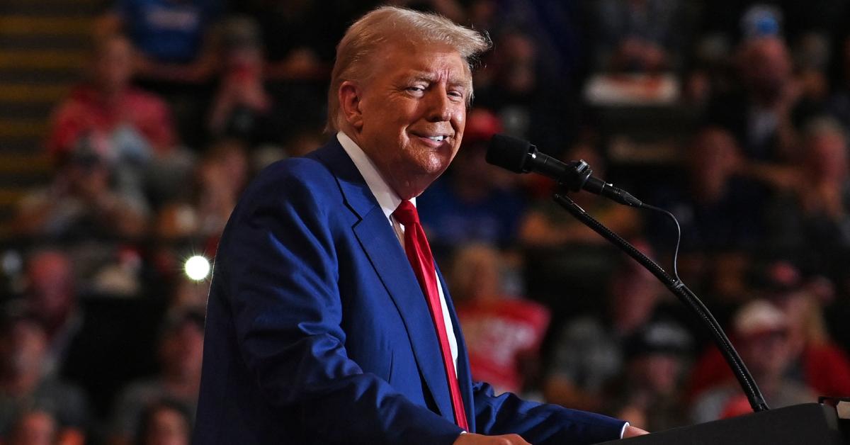 Donald Trump smiling while standing at the podium.