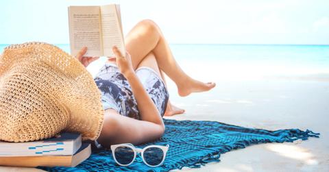 woman reading a book on the beach in free time summer holiday picture id