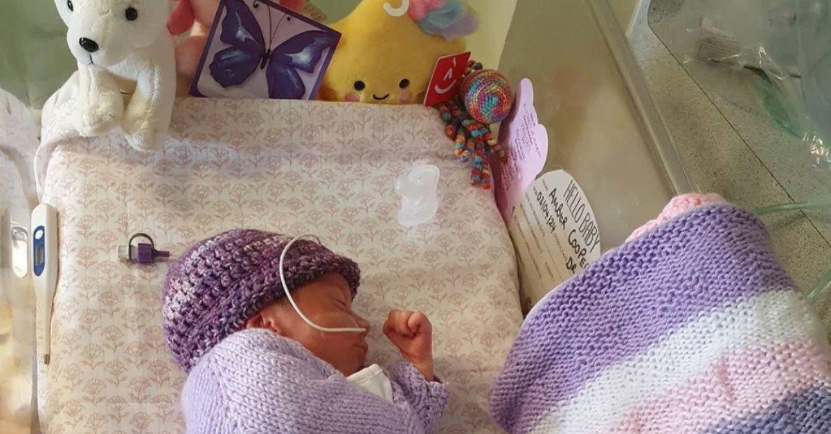 Purple butterfly sticker sits next to a newborn.